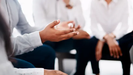 group of people sitting together. The photo is focused on their hands.