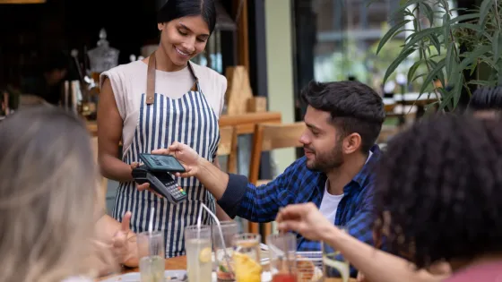 man paying a waitress with his phone