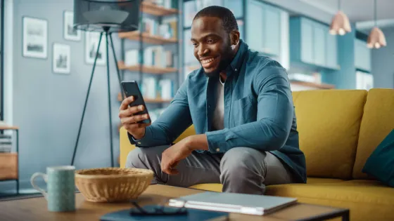 Man sitting on couch holding phone.