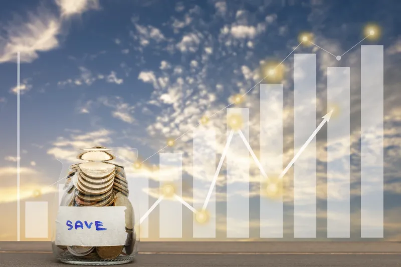 Savings investment jar with coins inside and a growing chart behind it