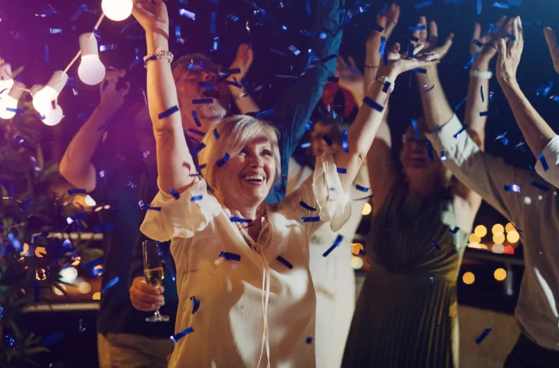 woman dancing with purple confetti falling around her