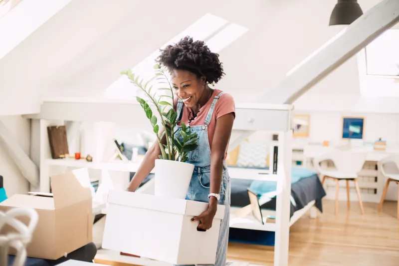 Woman smiling holding moving boxes.