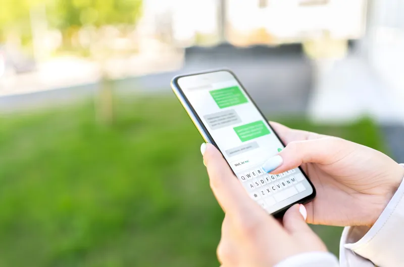 hand holding phone with a text message screen
