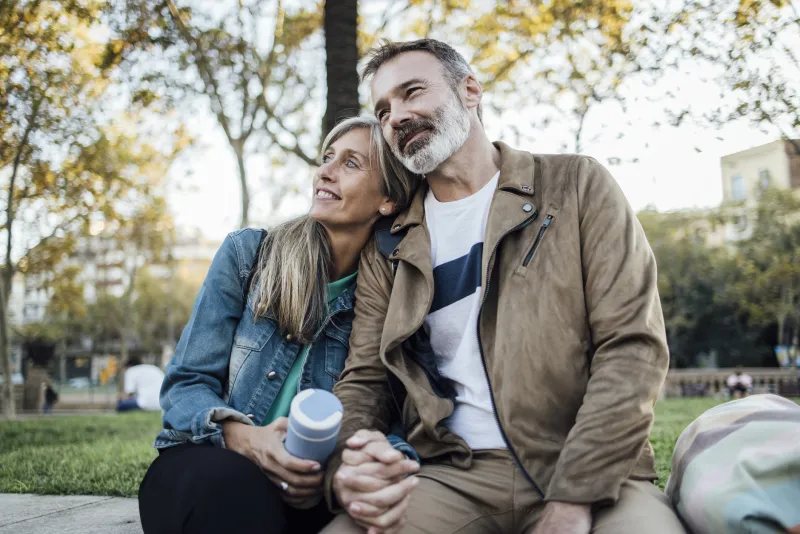 Man and woman sitting on a park bench.