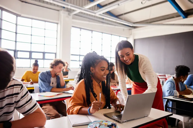 High School Students looking at a laptop