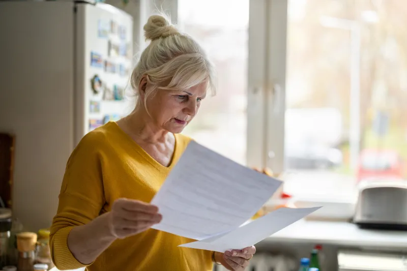 senior woman looking at her bank statement.