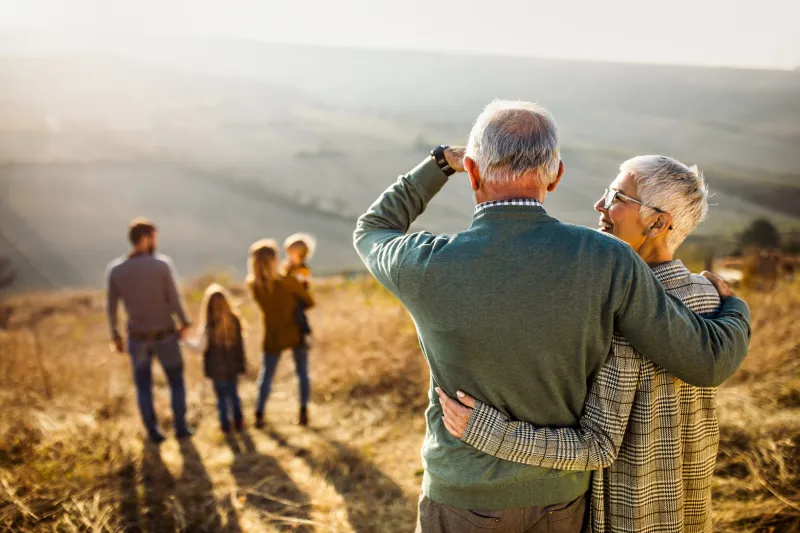 senior couple looking out over their young family.