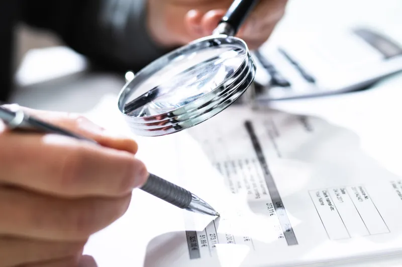 a magnifying glass looking over paperwork