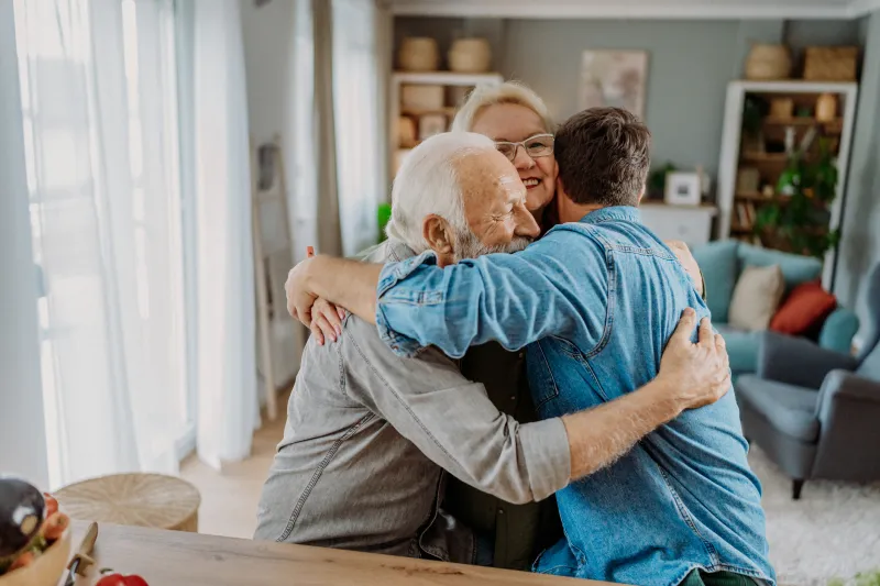 Grandparents hugging their grandson