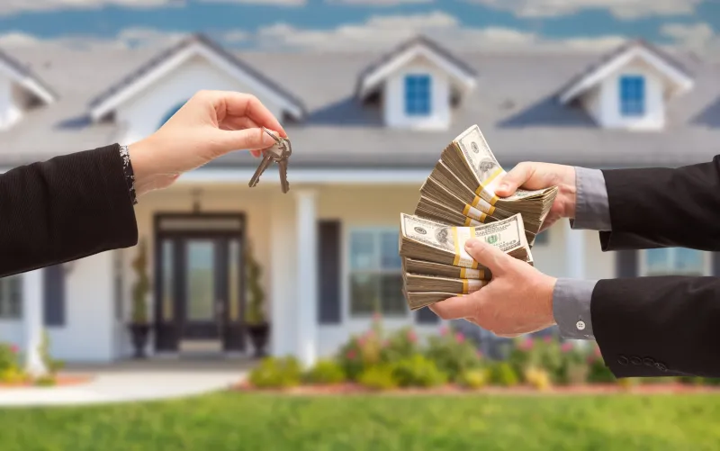 hands exchanging cash for house keys