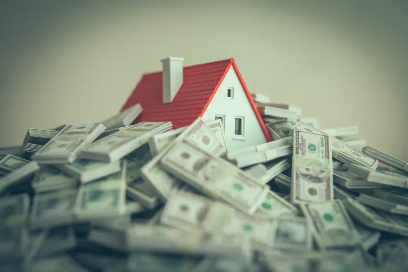 a house with a red roof buried in money