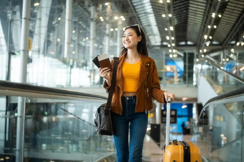 woman walking in a air port with luggage