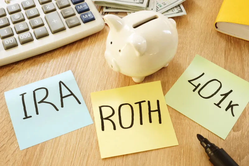 piggy bank with sticky notes reading 401(K), roth, and IRA