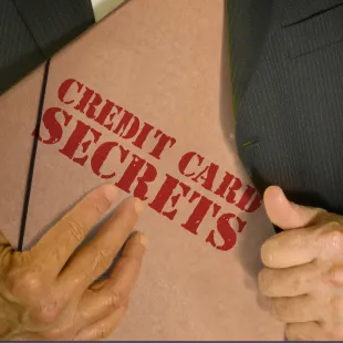 Hand holding file folder that reads, "credit card secrets"