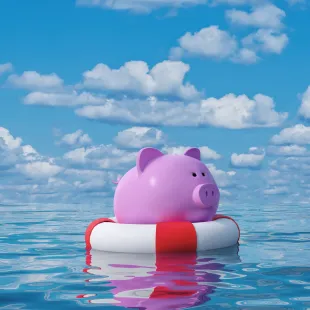 pink piggy bank floating in a red and white innertube in water. 