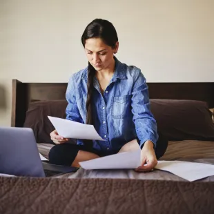 Woman looking at bills and her laptop