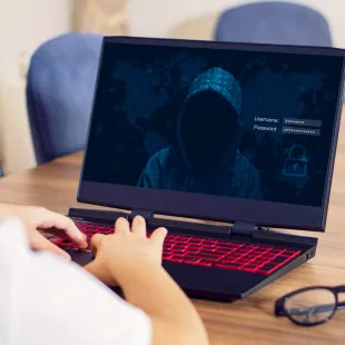 Child on laptop with a dark image of a thief on the screen