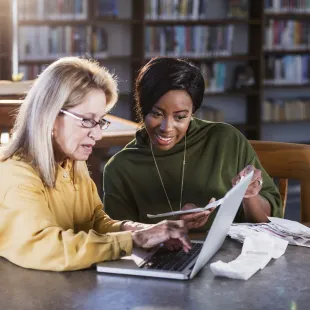 two women working on a computer together