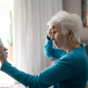 senior woman looking confused at her smart phone