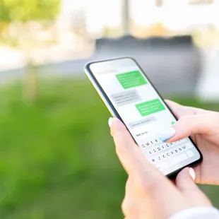 hand holding phone with a text message screen