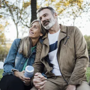 Man and woman sitting on a park bench.