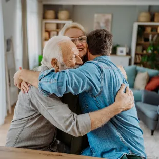 Grandparents hugging their grandson