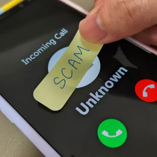 incoming phone call with a scam sticker on the screen