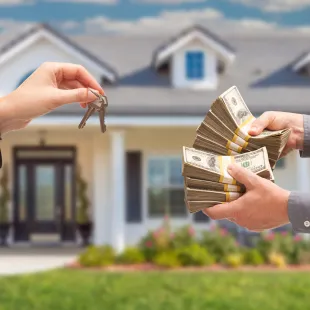 hands exchanging cash for house keys
