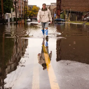 Man walking in a water covered street after a storm 