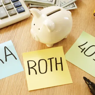 piggy bank with sticky notes reading 401(K), roth, and IRA