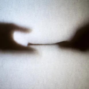 shadow of two hands exchanging money
