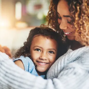 mother and young daughter hugging